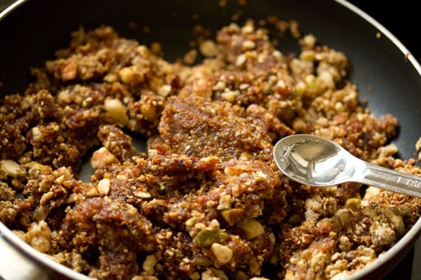 adding rose water for dry fruits barfi recipe.