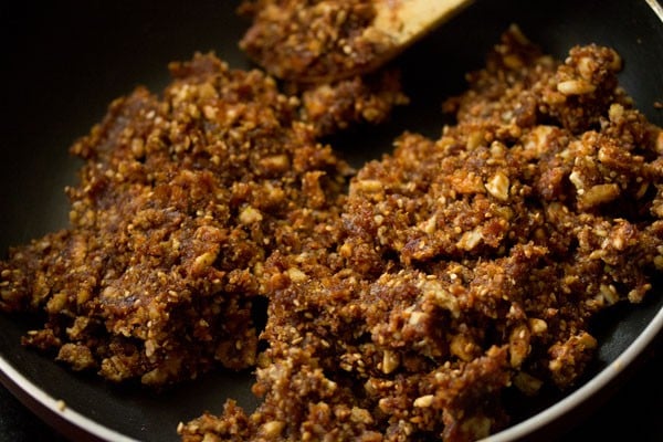 mixing dry fruits barfi together in the pan.