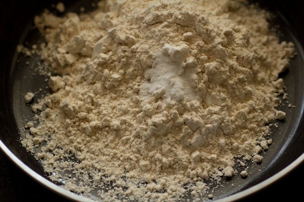 whole wheat flour and basking soda added in a bowl. 