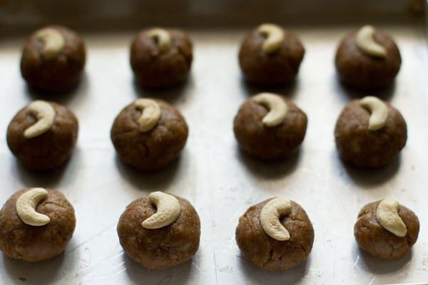 cashews placed on each dough ball on the tray. 