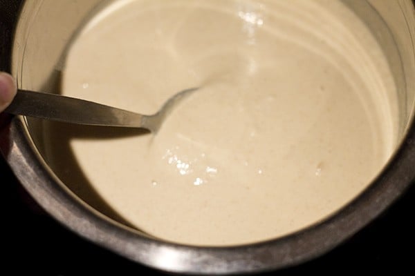 mixing salt into millet idli batter. 