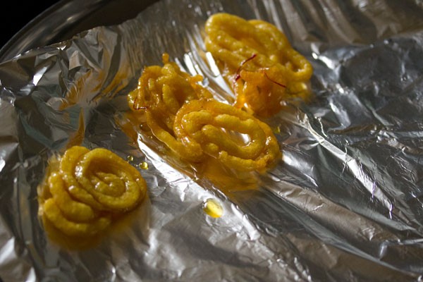 soaked jalebi on a foil lined tray