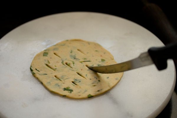  With a knife giving cuts on the rolled poori.