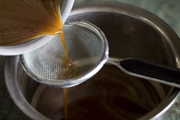 passing melted jaggery through a sieve to remove impurities. 