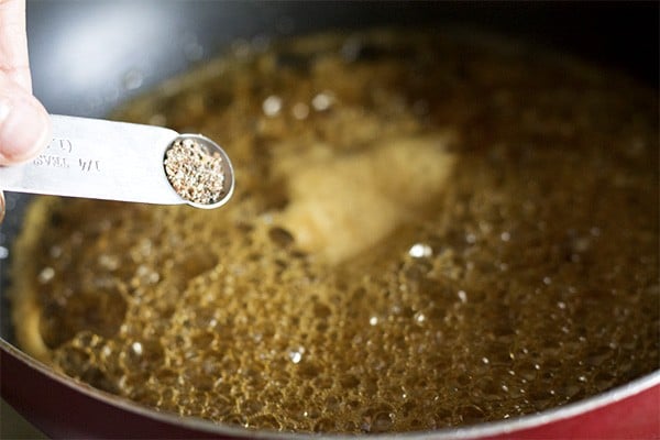 adding cardamom powder to frothing jaggery solution. 