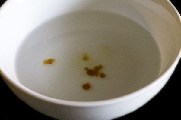 checking the thickness of the jaggery solution in water. 