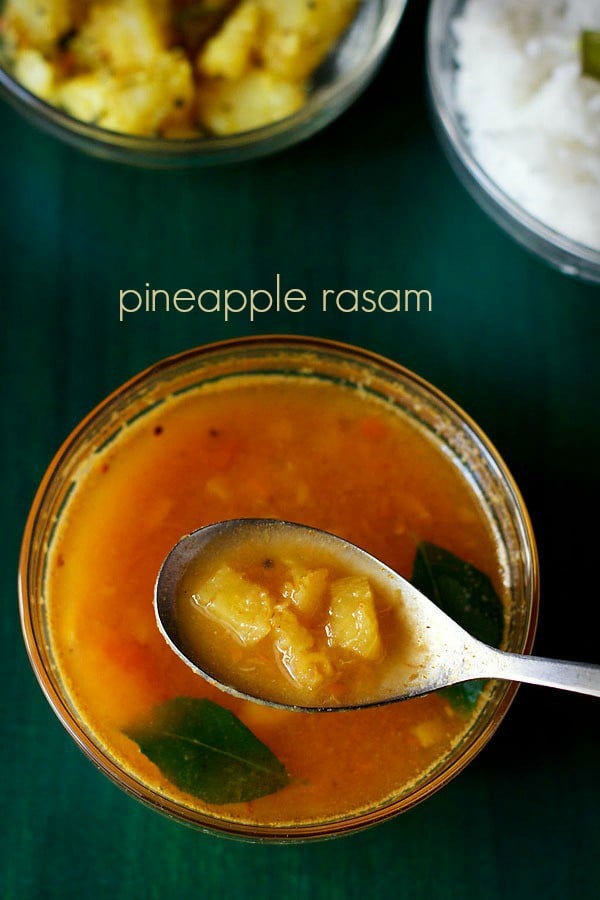 pineapple rasam in a spoon on top of bowl filled with pineapple rasam