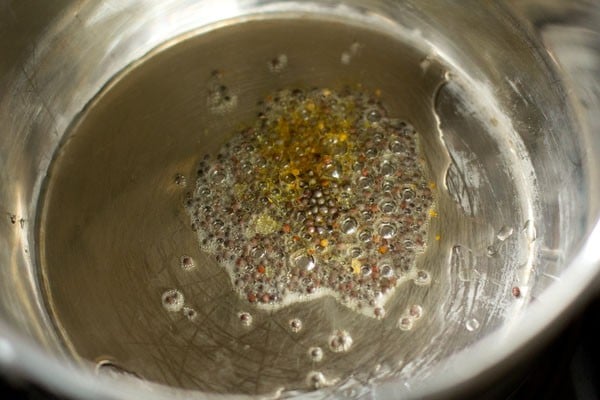 crackling mustard seeds in hot oil in pan