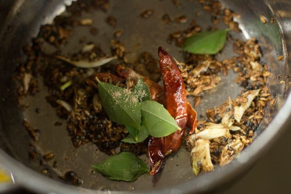 adding curry leaves and asafoetida to pan