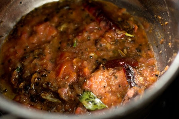 adding crushed tomatoes to pan