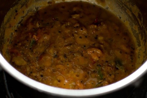 cooking pineapple puree with crushed tomatoes in pan