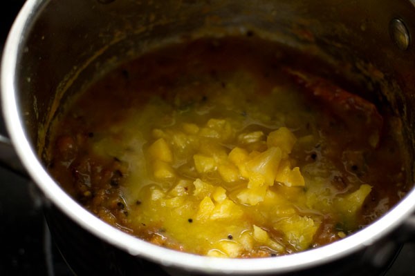 adding chopped pineapple cubes to pan