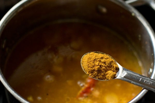 adding rasam powder to pan