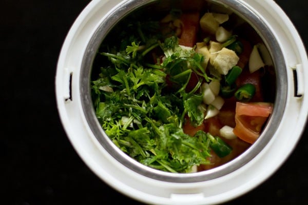 tomato and herbs in a grinder jar