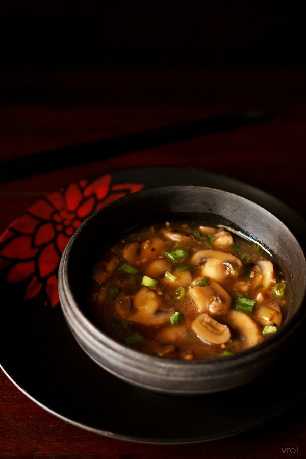 chinese mushroom in spicy soy sauce served in a black bowl. 