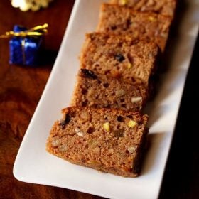 slices of Kerala plum cake on a white rectangular plate