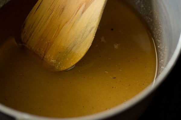 stirring sugar solution with a wooden spatula