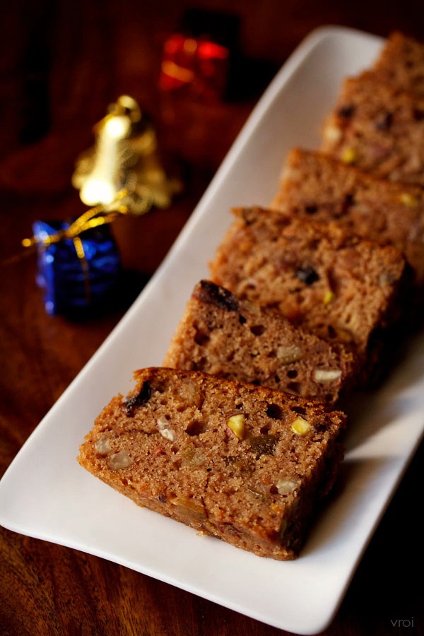 slices of Kerala plum cake on a white rectangular plate