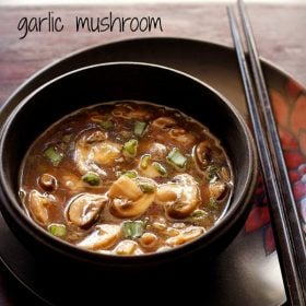 chinese mushroom in spicy soy sauce served in a black bowl with 2 chopsticks kept on right side and text layover.