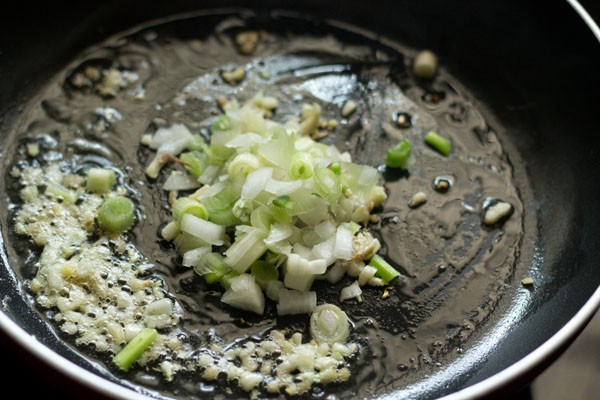 finely chopped spring onion whites added to the wok. 