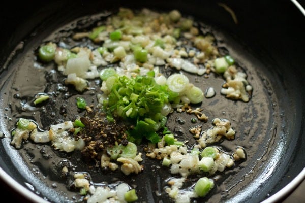 crushed black pepper and crushed sichuan peppers added to the wok. 