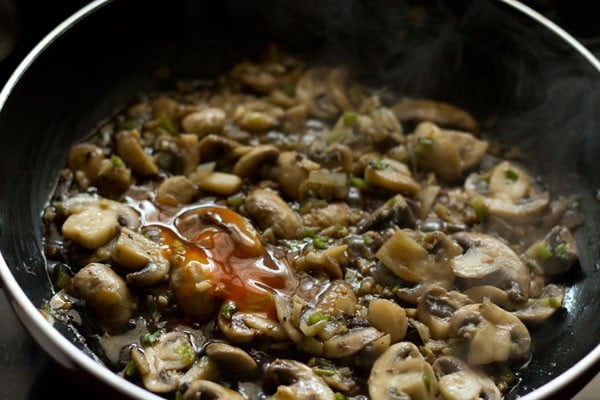 red chili sauce added to the mushrooms in the wok. 