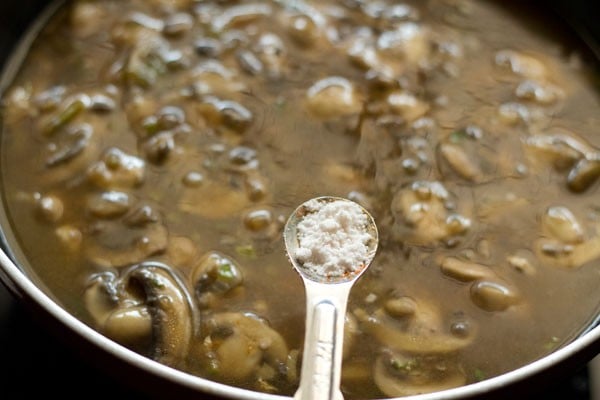 adding salt to simmering mushroom sauce. 