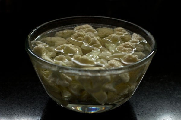 cauliflower florets blanching in water in glass bowl to make gobi 65 recipe