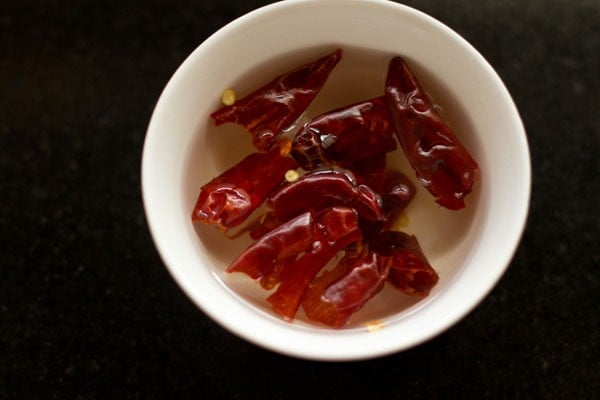 red chillies soaking in water in white bowl