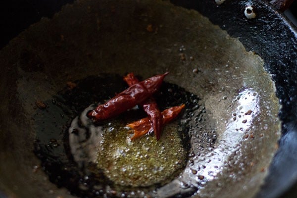 mustard seeds sizzling in hot oil with dry red chillies