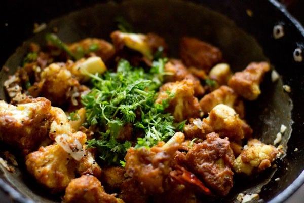 chopped coriander leaves on gobi 65 in pan