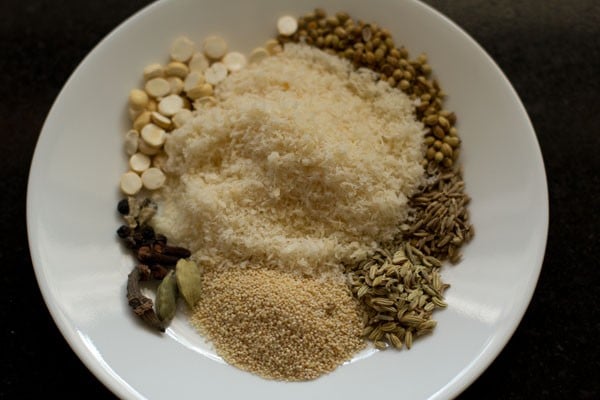 spices, nuts and seeds on a white plate to make kurma paste