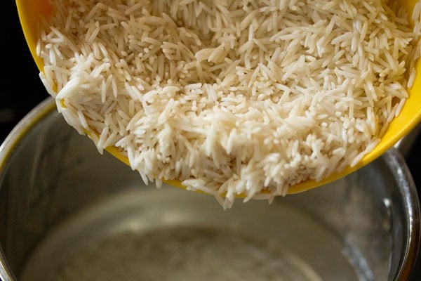 adding drained basmati rice in the pan. 