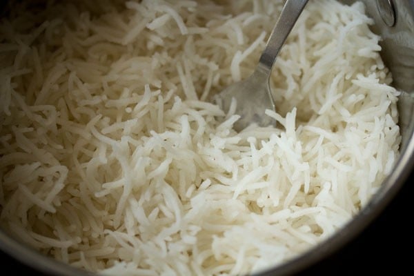 fluffing the cooked basmati rice in the pan. 
