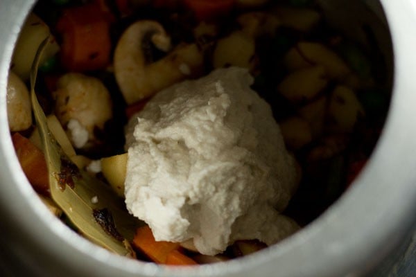 adding ground white paste for Mughlai biryani