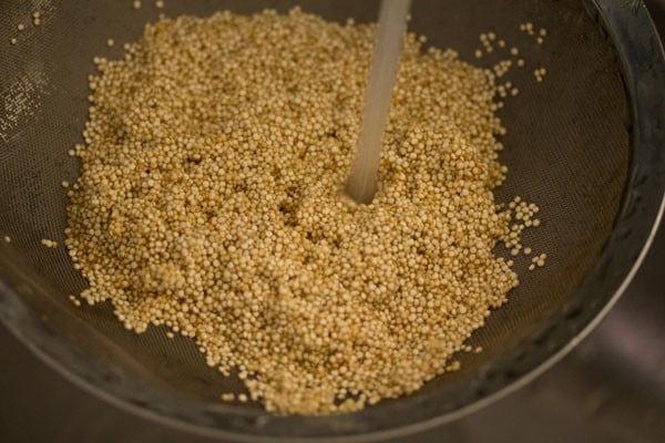 rinsing quinoa seeds under running water