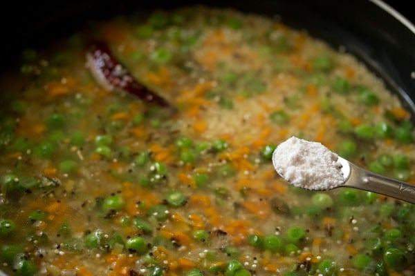 salt being added with a measuring spoon