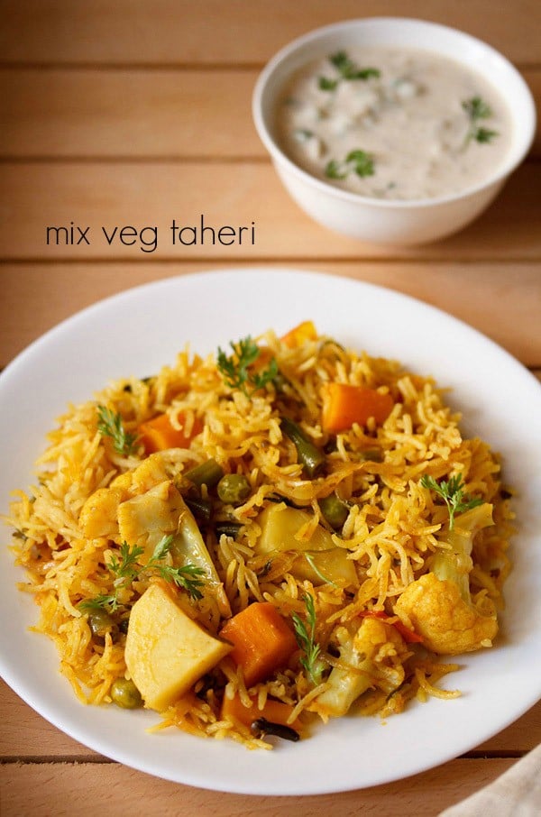 vegetable tehri served on a white plate with a small bowl of raita kept on the top right side and text layovers.