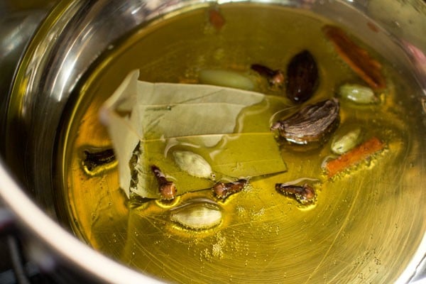 sautéing whole spices in hot ghee. 