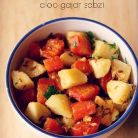 aloo gajar ki sabji served in a blue rimmed bowl with text layover.