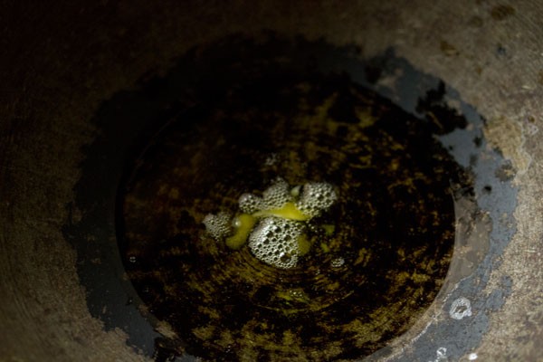 melting ghee in a thick bottomed pan for making carrot burfi. 