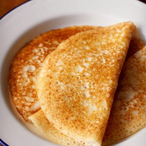 davangere benne dosa served on a blue rimmed white plate with text layover.