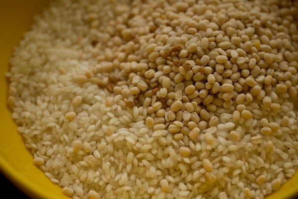 parboiled rice and urad dal in a bowl