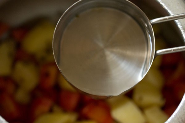 adding water to the vegetables. 