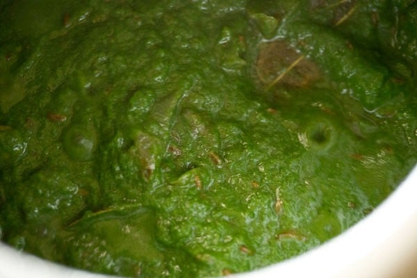Spinach puree and spices being stirred 