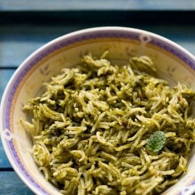 Palak rice garnished with a mint leaf in a bowl