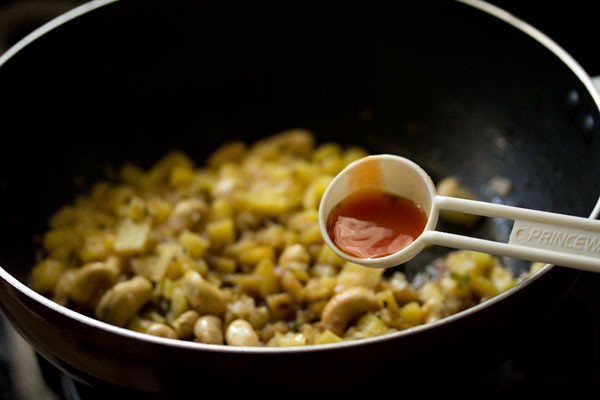 adding red chili sauce in the wok. 