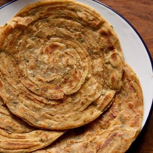 pudina paratha served on a blue rimmed white plate.