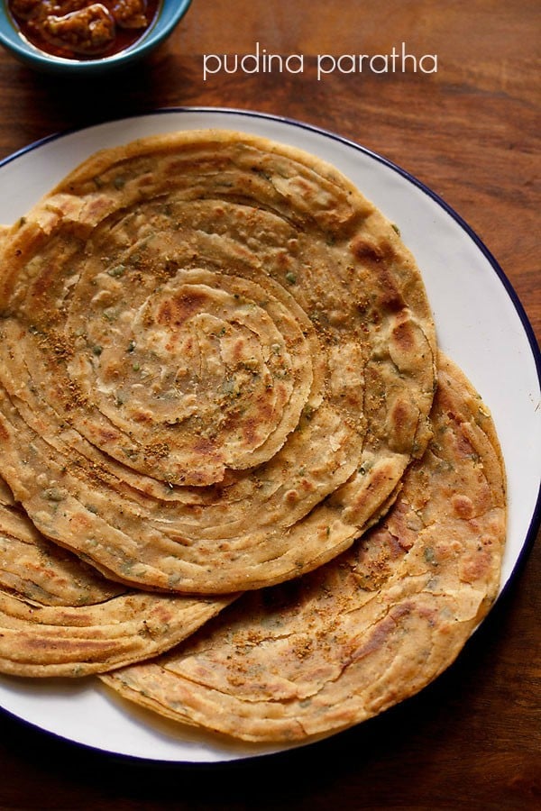 pudina paratha served on a blue rimmed white plate.