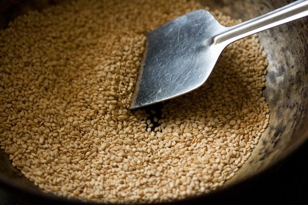 stirring and roasting sesame seeds for making sesame laddu. 